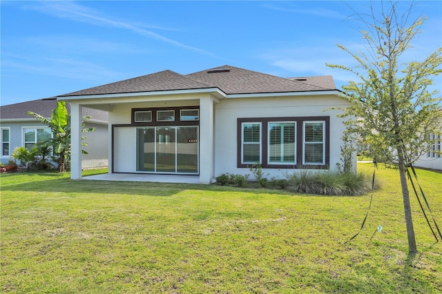 back of property featuring a lawn, a patio area, stucco siding, and roof with shingles