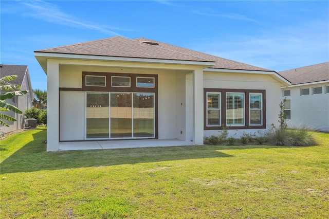 rear view of property with roof with shingles, a patio area, cooling unit, a yard, and stucco siding