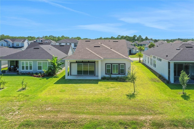 back of property with a lawn, a shingled roof, stucco siding, and a residential view