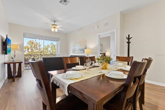 dining area featuring baseboards, visible vents, light wood finished floors, and ceiling fan