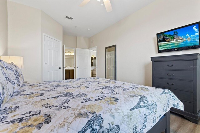 bedroom with visible vents, wood finished floors, ensuite bath, and a ceiling fan