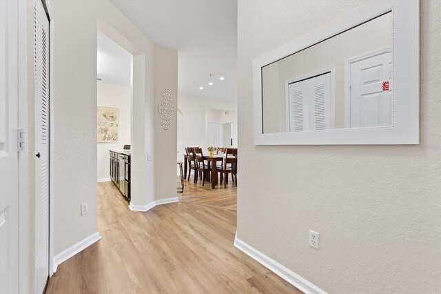 hallway featuring baseboards and light wood-style flooring