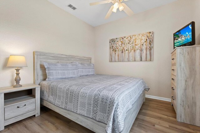 bedroom with visible vents, ceiling fan, baseboards, and wood finished floors