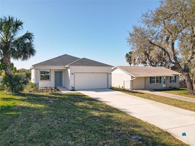 ranch-style home featuring a shingled roof, a front lawn, concrete driveway, stucco siding, and a garage