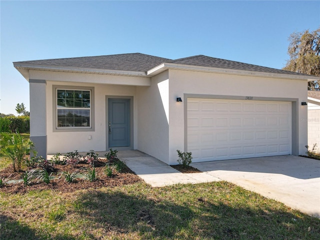 view of front of house featuring stucco siding, concrete driveway, a garage, and roof with shingles