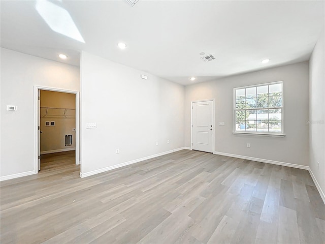 spare room featuring recessed lighting, visible vents, light wood-style flooring, and baseboards