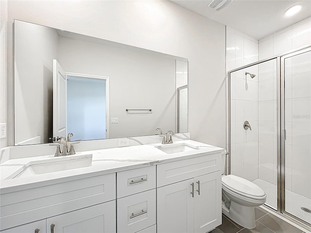 bathroom with a shower stall, toilet, double vanity, and a sink