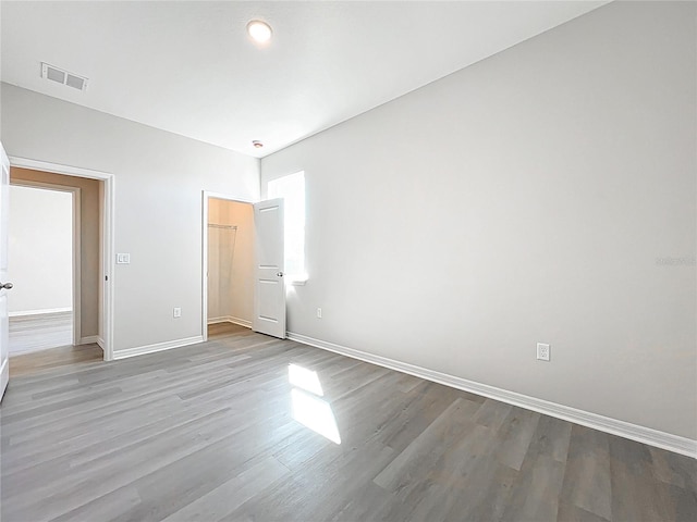 unfurnished bedroom with visible vents, baseboards, and wood finished floors