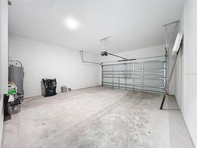 garage with concrete block wall, a garage door opener, and water heater