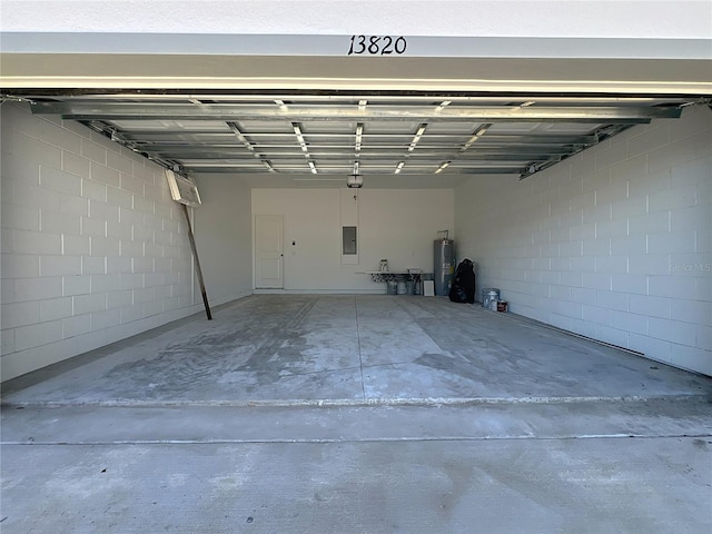 garage featuring electric panel and electric water heater