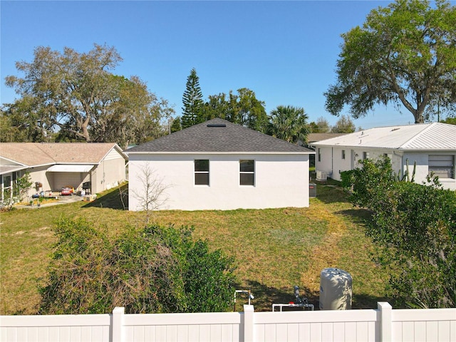 view of home's exterior featuring a yard, fence, and stucco siding