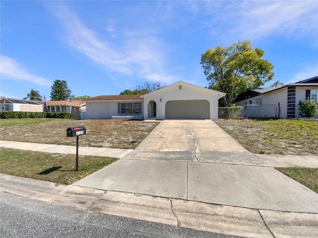 ranch-style house with concrete driveway, fence, a garage, and stucco siding