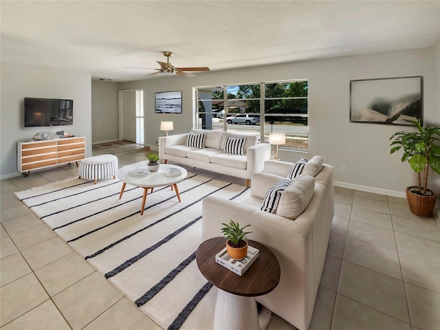 tiled living room featuring baseboards and ceiling fan