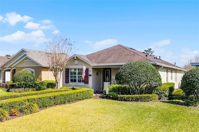 ranch-style home with stucco siding, a front lawn, and a shingled roof