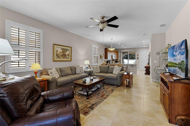 living room featuring visible vents, light tile patterned flooring, recessed lighting, ceiling fan, and a textured ceiling