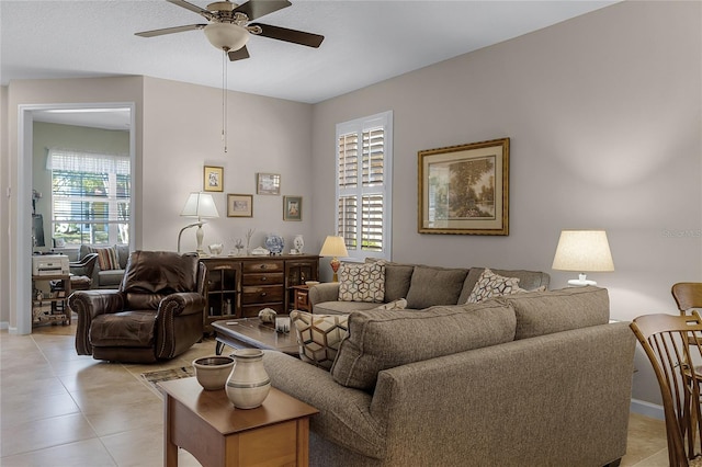 living room with baseboards, light tile patterned flooring, and a ceiling fan