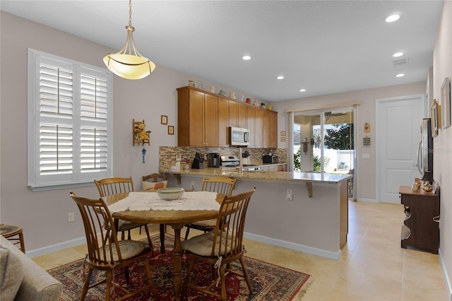 dining room with recessed lighting, baseboards, and light tile patterned flooring