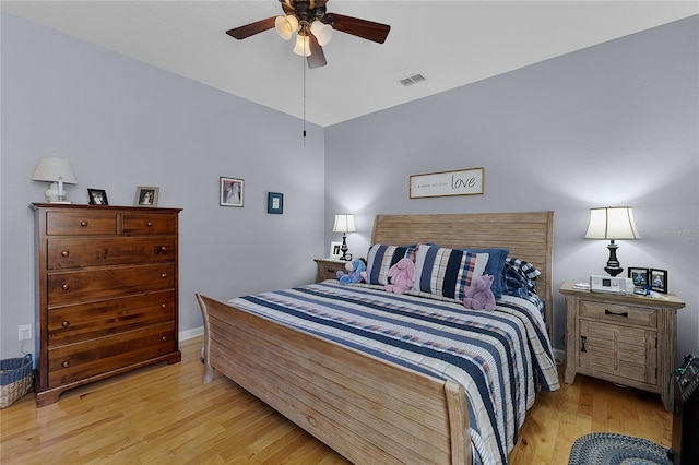 bedroom with baseboards, a ceiling fan, visible vents, and light wood-type flooring