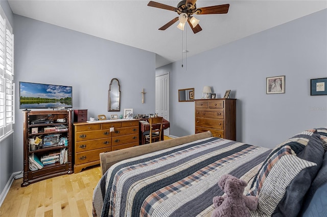 bedroom featuring a ceiling fan, a closet, and light wood finished floors