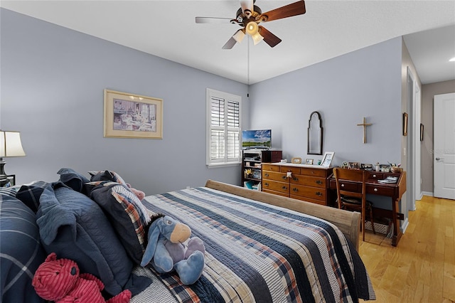 bedroom featuring baseboards, light wood-type flooring, and ceiling fan