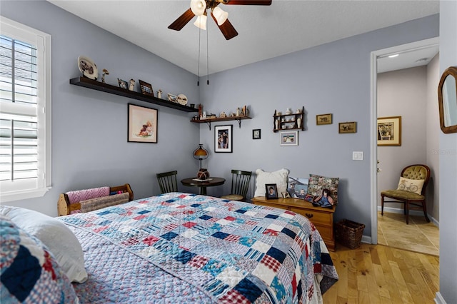 bedroom featuring light wood-style floors, baseboards, and ceiling fan