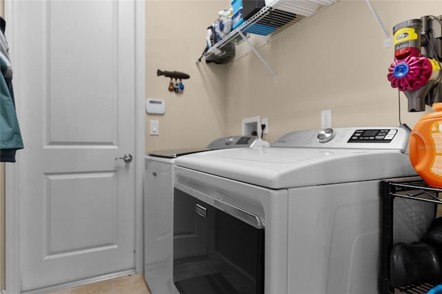 washroom with laundry area, light tile patterned floors, and washing machine and dryer