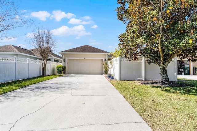 view of front facade featuring a front lawn, fence, driveway, and stucco siding