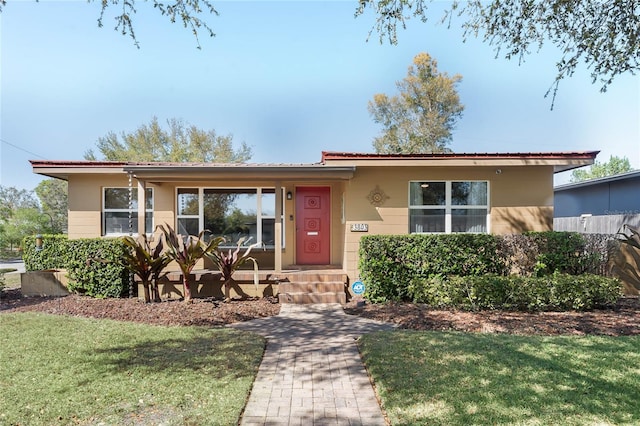 ranch-style house featuring a porch and a front yard