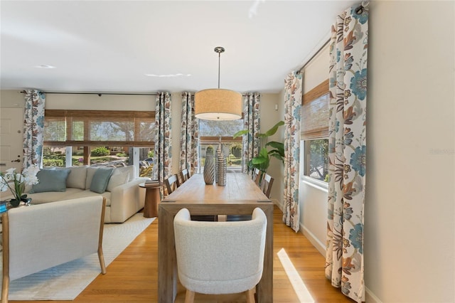 dining area with a wealth of natural light, light wood-type flooring, and baseboards