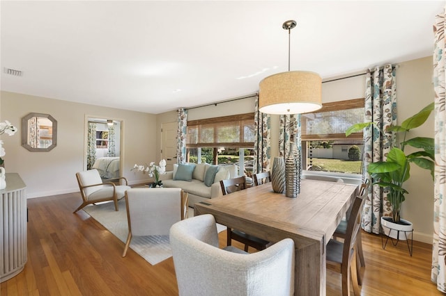 dining space featuring visible vents, baseboards, and wood finished floors