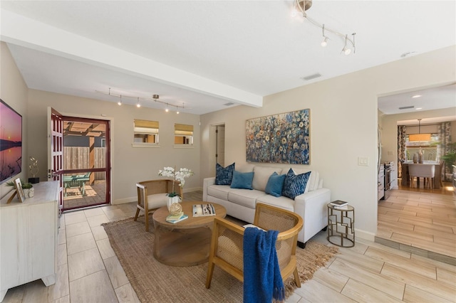 living room featuring beam ceiling, visible vents, wood finish floors, and baseboards