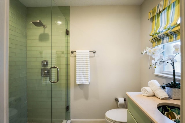 full bathroom featuring vanity, a shower stall, toilet, and baseboards