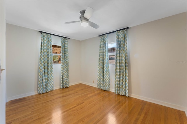 unfurnished room featuring baseboards, a ceiling fan, and light wood-style floors