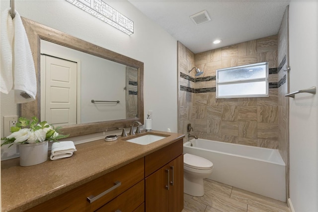 bathroom with visible vents, toilet,  shower combination, and vanity