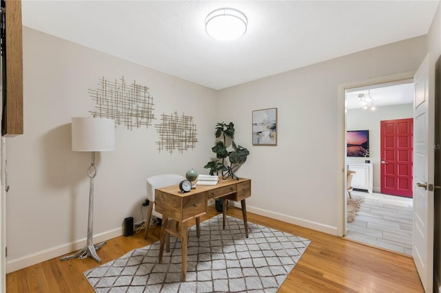 office space featuring light wood-type flooring and baseboards