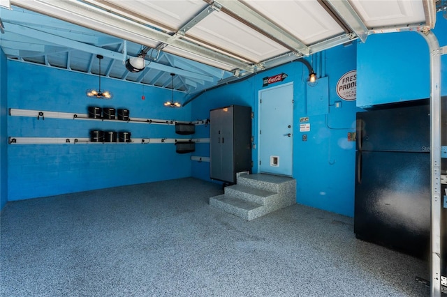 garage with a garage door opener and freestanding refrigerator