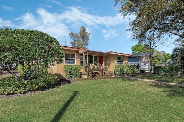 single story home featuring stucco siding and a front yard