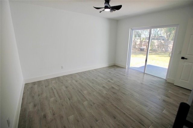 unfurnished room featuring wood finished floors, baseboards, and ceiling fan