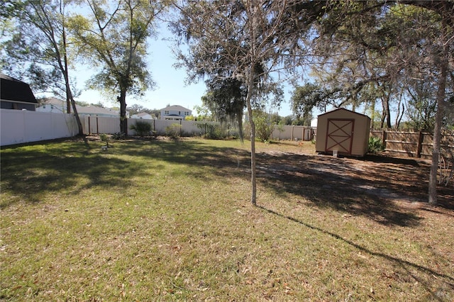 view of yard featuring an outbuilding, a storage unit, and a fenced backyard