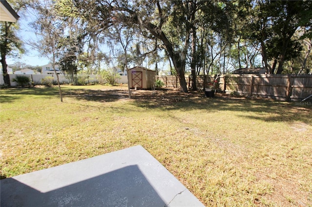 view of yard featuring an outbuilding, a storage unit, and a fenced backyard