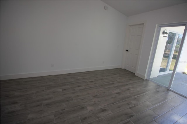 empty room featuring baseboards and wood tiled floor