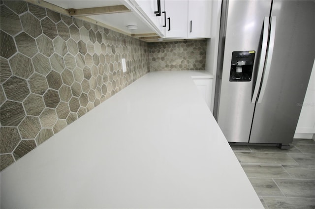 below grade area featuring stainless steel fridge with ice dispenser