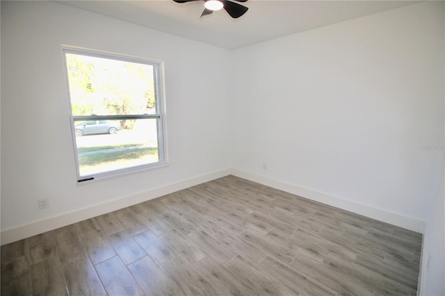 empty room with baseboards, wood finished floors, and a ceiling fan