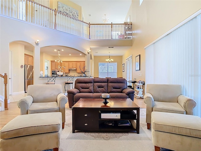 living room featuring arched walkways and a chandelier