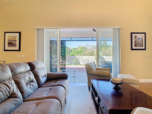 living room with wood finished floors, baseboards, and ceiling fan