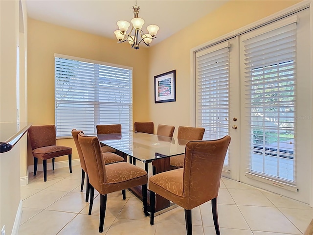 dining area featuring baseboards, an inviting chandelier, and light tile patterned flooring