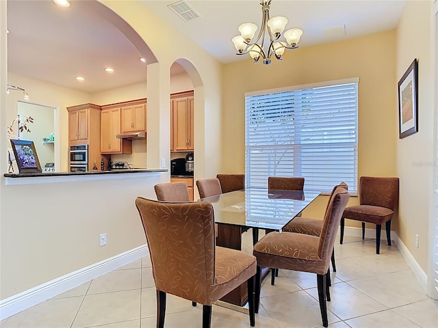 dining space featuring baseboards, visible vents, light tile patterned flooring, arched walkways, and a notable chandelier