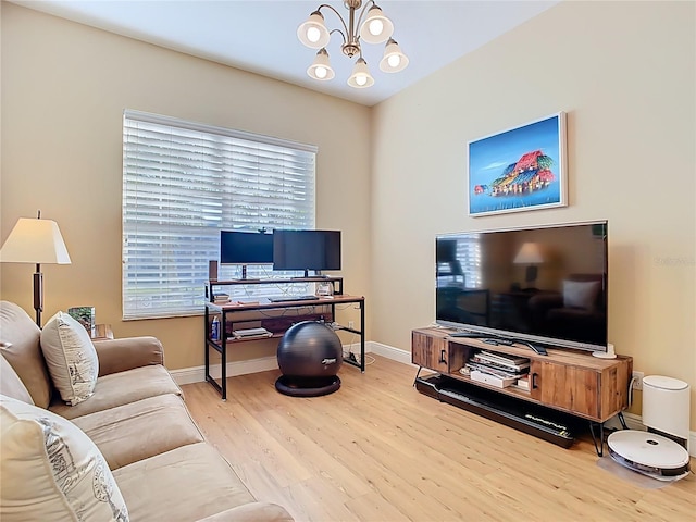 living room featuring wood finished floors, baseboards, and a chandelier