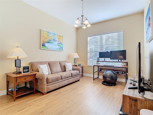 living area featuring a notable chandelier, light wood-style flooring, and baseboards