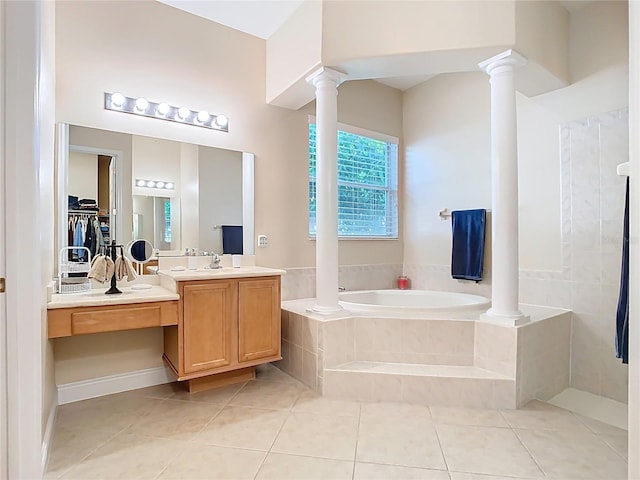 full bath with vanity, ornate columns, tile patterned flooring, a spacious closet, and a garden tub